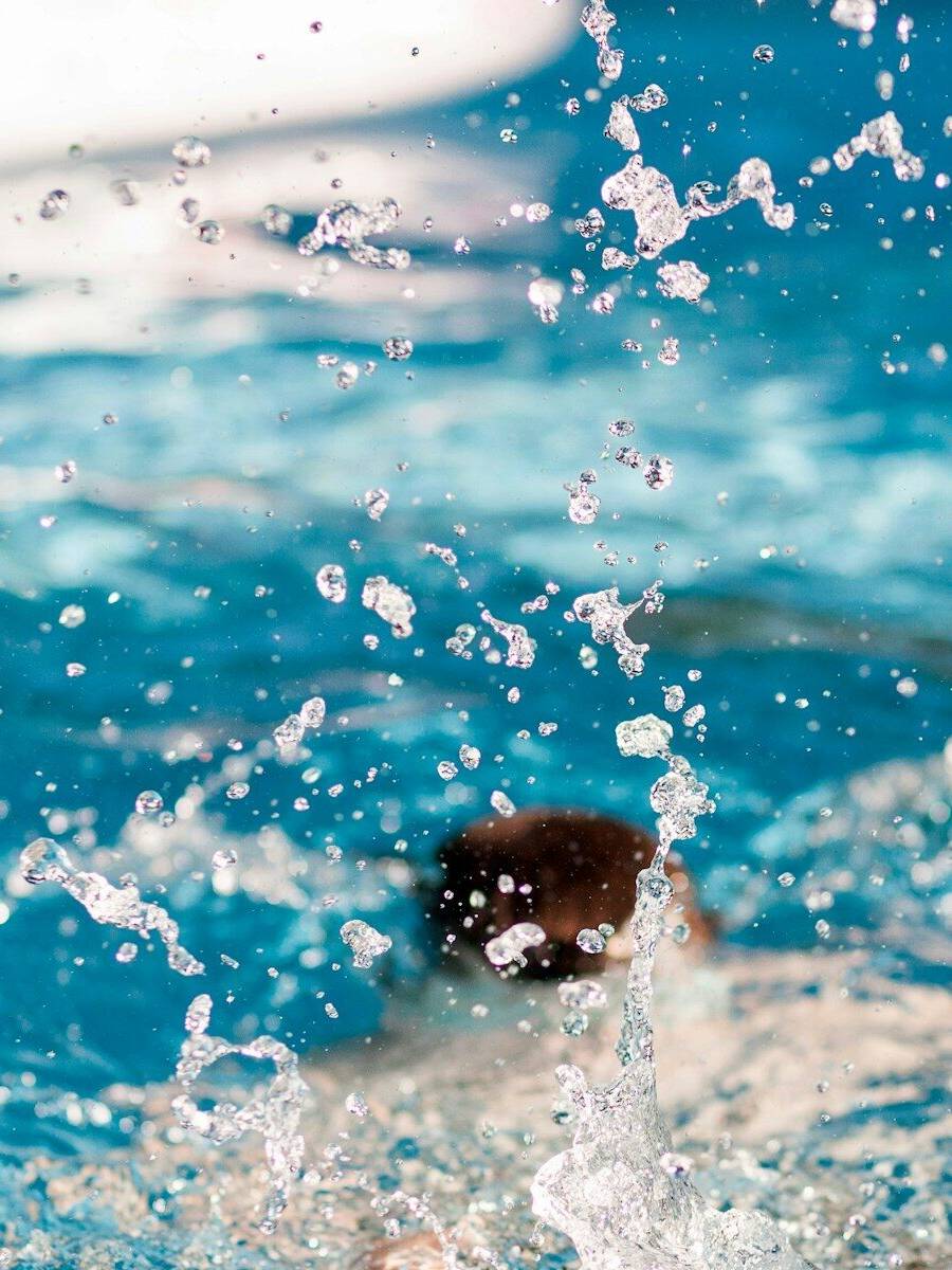 person diving on pool splashing water