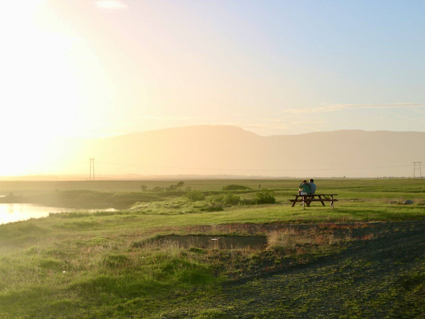 a person sitting on a bench near a body of water